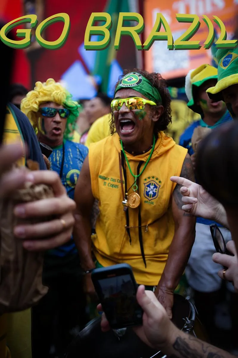 Energetic Brazilian superfan in yellow shirt screaming GO BRAZIL with neon sunglasses and headband, fan in colorful wig beside him